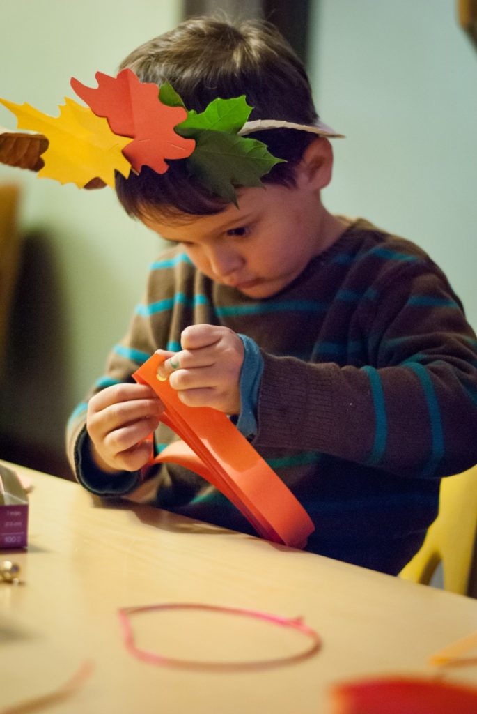 A young boy is cutting paper with scissors.